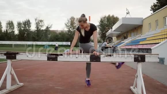 年轻女孩在训练前揉捏运动员把苍蝇腿靠在一边视频的预览图