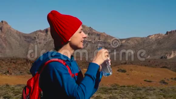 徒步旅行的女人在Tenerife的Tide徒步旅行后喝水加那利群岛特内里费的白人女性游客慢慢视频的预览图
