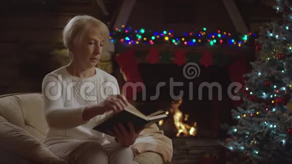 老太太晚上在圣诞树旁看书视频的预览图