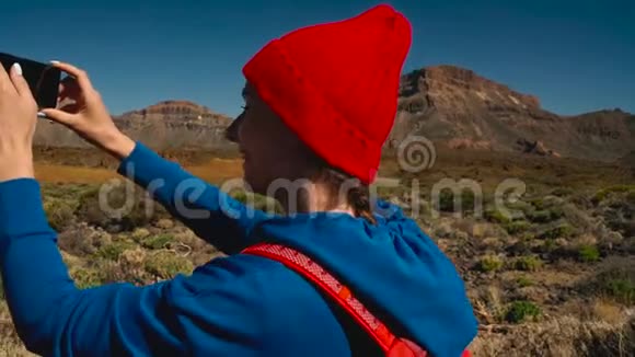 活跃的徒步旅行者女性徒步旅行在Teide国家公园并在智能手机上制作照片景观高加索青年妇女视频的预览图