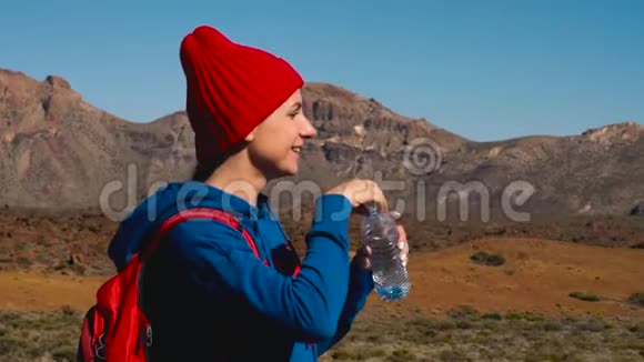徒步旅行的女人在Tenerife的Tide徒步旅行后喝水加那利群岛特内里费的白人女性游客慢慢视频的预览图