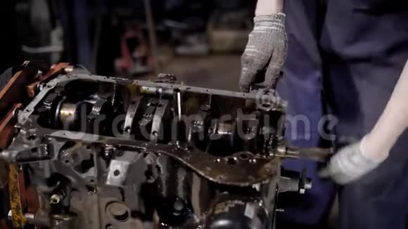 作物修理工站岗并在车间维修油状发动机视频的预览图