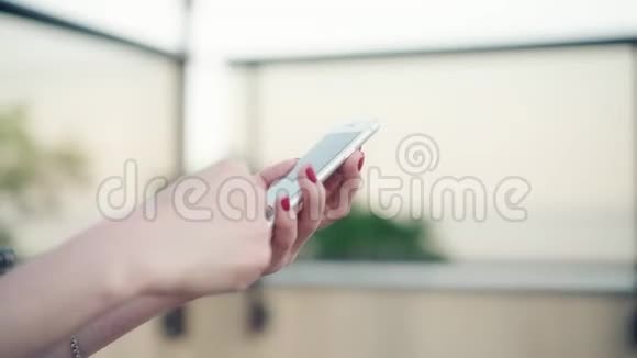 特写女性手握智能手机在触摸屏上输入文本女人在社交场合回复朋友信息视频的预览图