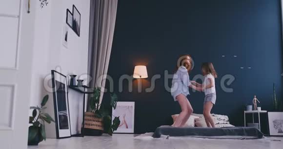 母亲和女儿在床上跳跃快乐快乐视频的预览图