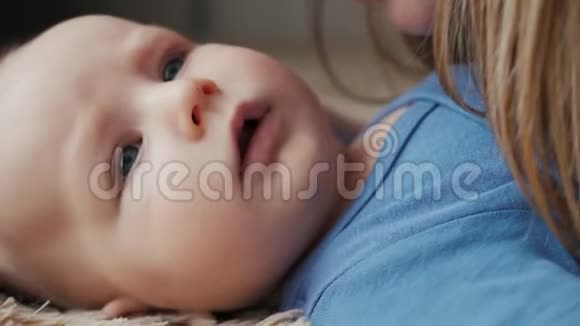 一个美丽的女人亲吻婴儿的肖像母亲亲吻她新生的婴儿视频的预览图