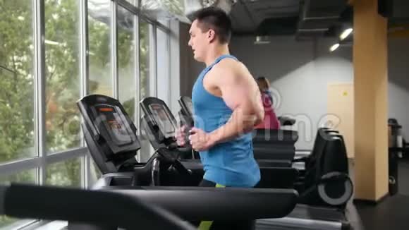 健身房里强壮的男人健身者在健身房的跑道上跑步滑块视频的预览图