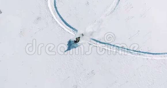 雪地摩托骑在田野上从无人驾驶飞机上俯瞰视频的预览图