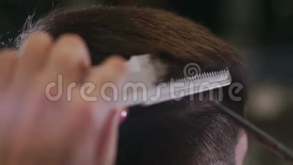 特写主理发师用剪刀和梳子做发型和风格概念理发店视频的预览图