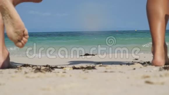 一对幸福的年轻夫妇在沙滩上奔向大海手牵着手男孩和女孩在一起玩得很开心视频的预览图