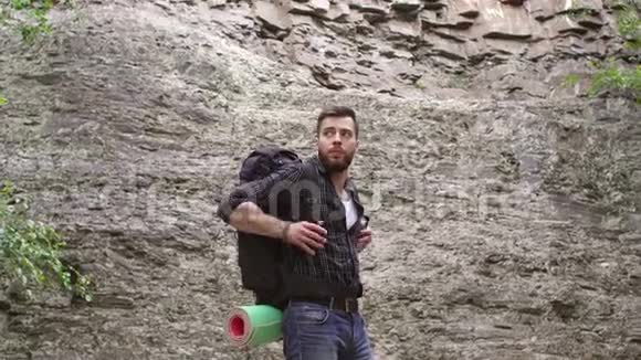 在山上背包的男性徒步旅行者的特写视频的预览图