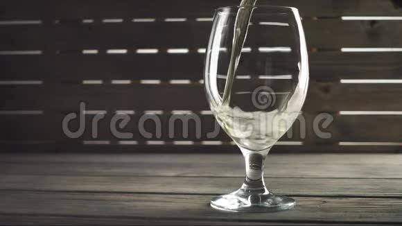 啤酒倒在木头背景上的玻璃上泡沫从侧面滑下来慢动作视频的预览图