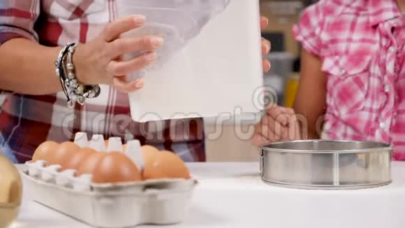 在厨房女儿用筛子筛面粉视频的预览图