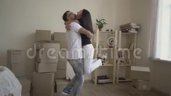 一对年轻夫妇轻松地搬进了一所新房子里面有未包装的盒子视频的预览图