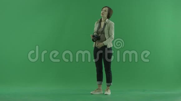 一位年轻女子正在绿色屏幕上左手边拍照视频的预览图