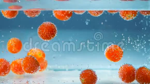 抽象背景红西红柿在蓝色的水中上升和下降视频的预览图