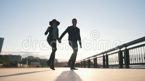 快乐的一对在户外跳舞的夫妇男人和女人在日落时玩得很开心视频的预览图