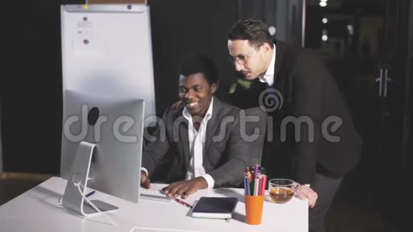 办公室里有两个人在电脑前交流视频的预览图