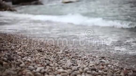 海浪在海岸上翻滚着鹅卵石视频的预览图