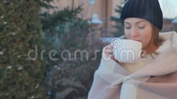 可爱的红唇女孩在冬天喝热茶取暖的肖像视频的预览图