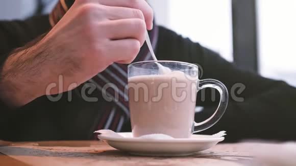 一个男人在一家咖啡馆里吃商务午餐用透明的杯子搅拌饮料视频的预览图