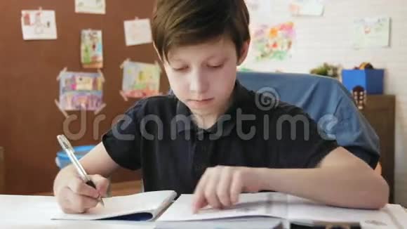 可爱的小男孩在他的房间里做学生书上的练习视频的预览图