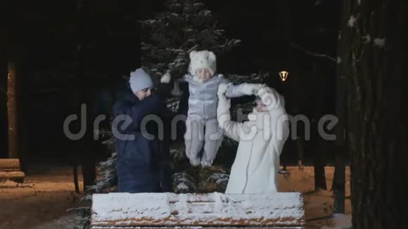 幸福的家庭在冬天的傍晚公园挥手视频的预览图