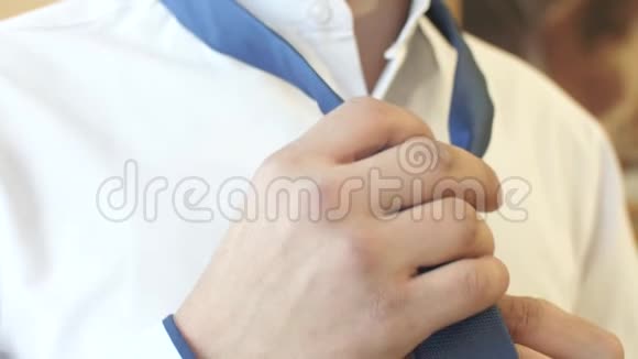 男人穿上一条蓝色领带一件白色衬衫视频的预览图