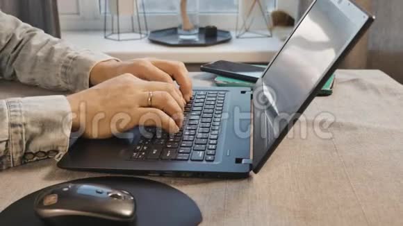 男性手在笔记本电脑的键盘上打字特写镜头自由职业者在家工作视频的预览图