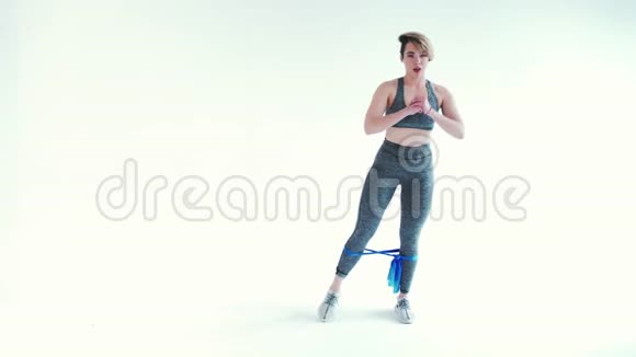 健身妇女用白色背景带做运动视频的预览图