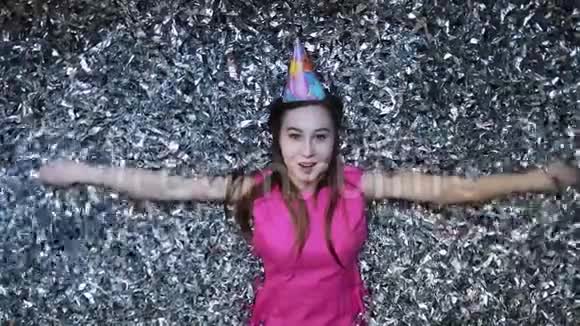 穿着粉色裙子的年轻女士用彩纸庆祝新年或生日视频的预览图