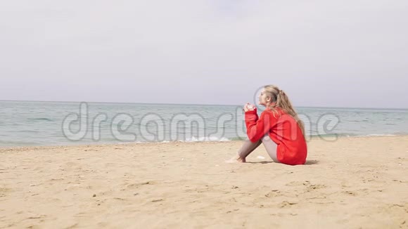 一个女孩坐在沙滩上看着大海视频的预览图