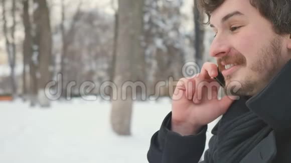 有魅力的男人在冬季公园打电话视频的预览图