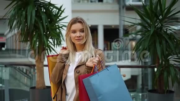 女孩站在商场里肩上扛着购物袋视频的预览图