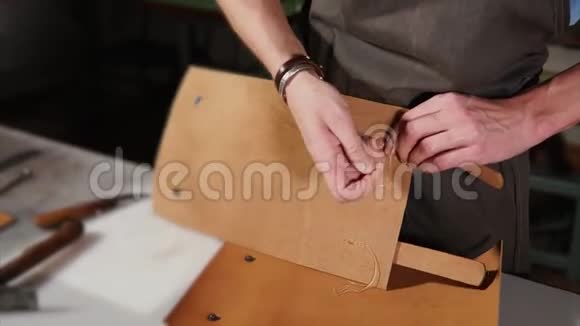 人类正在用手工缝制皮革用剪刀剪线视频的预览图