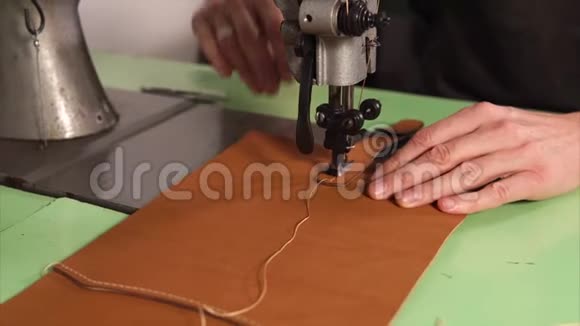 斯金纳正在用工业缝纫机在皮包上缝针视频的预览图