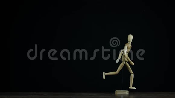 停止运动运行的木制人物假人旋转在工作室的黑色背景为标题视频的预览图