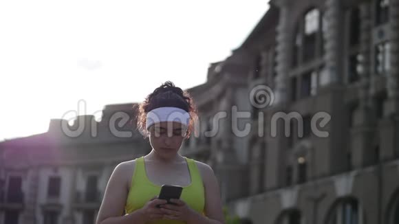 一位健康的健身妇女在户外晨练后在户外公园晨跑检查后的肖像视频的预览图