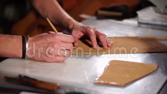 工匠是涂抹粘合剂的边缘切割细节为皮包视频的预览图