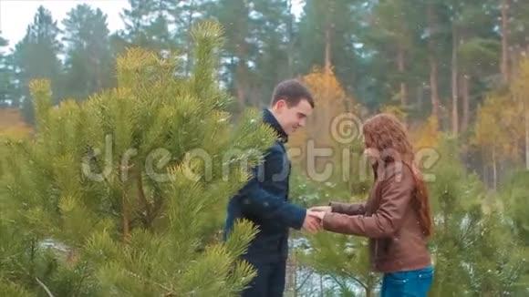 恋爱中的情侣牵着手在松林中嬉笑欢闹慢动作视频的预览图