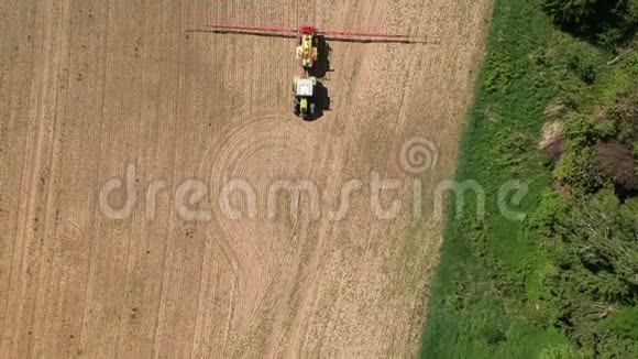早春农业拖拉机喷播作物芽空中视频的预览图