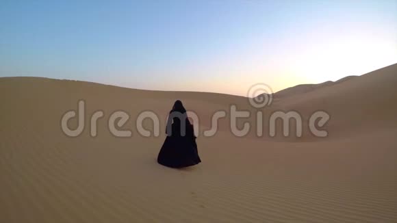 穿着传统阿联酋服装的年轻女子在沙漠中视频的预览图
