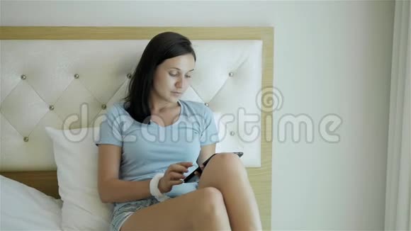 清晨躺在床上使用平板电脑的少女视频的预览图