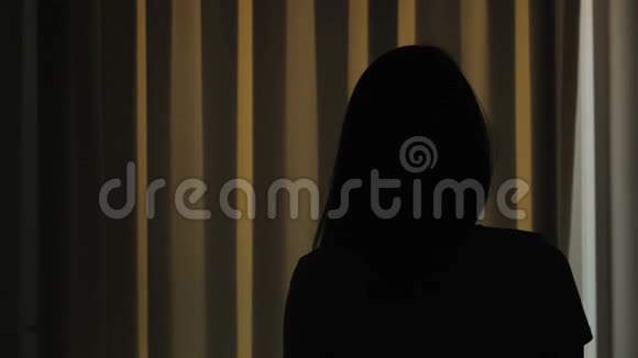 年轻的女人在卧室里打开窗帘透过窗户观赏海景棕榈树和山脉视频的预览图