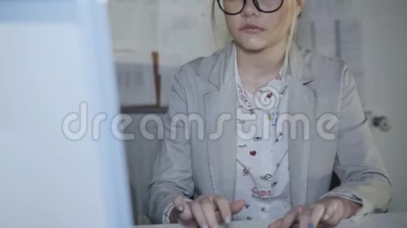 戴眼镜的年轻办公室女孩在办公室里用电脑工作4K视频的预览图