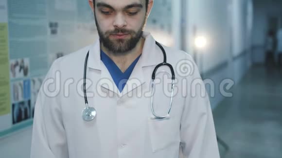 英俊的医生在医院看相机的肖像4K视频的预览图