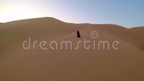 穿着传统阿联酋服装的年轻女子在沙漠中视频的预览图