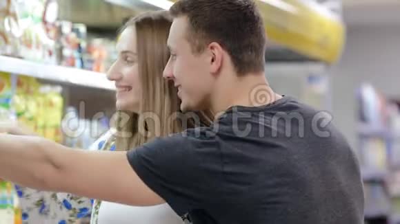 年轻夫妇在超市里选择杂货店视频的预览图