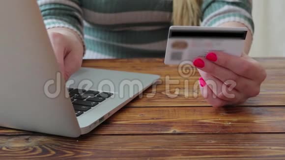 年轻女子用假信用卡和笔记本电脑在网上买衣服视频的预览图