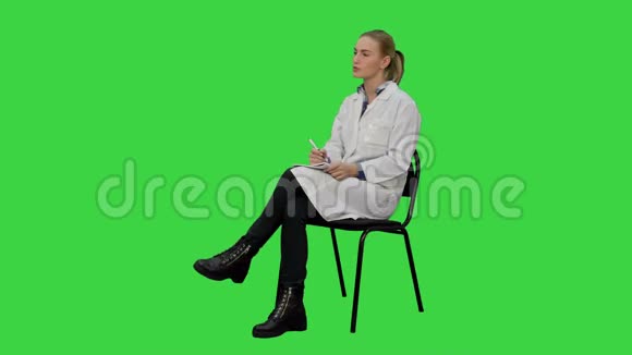 女医生与病人交谈并在绿色屏幕上的笔记本上写字Chroma键视频的预览图