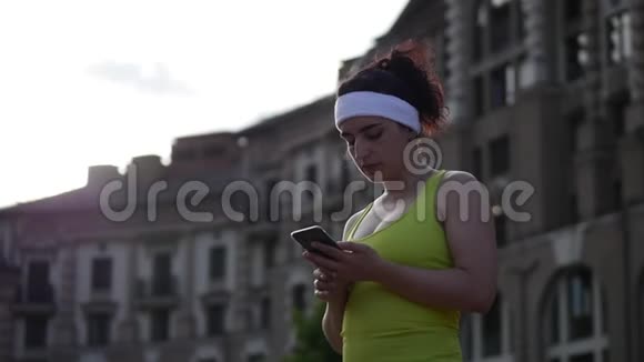 一位健康的健身妇女在户外晨练后在户外公园晨跑检查后的肖像视频的预览图